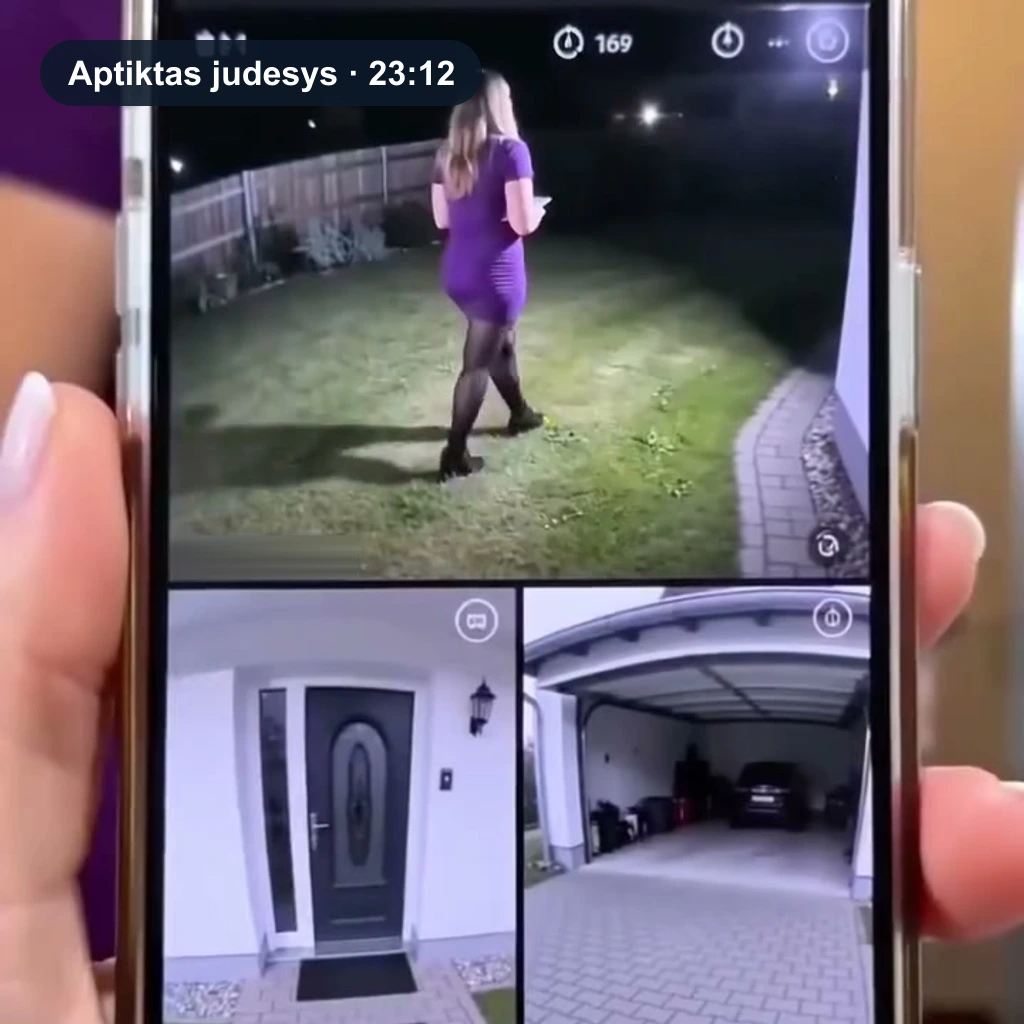 Ranka laiko telefoną su pranešimu „Aptiktas judesys“: tiesioginiame vaizde žmogus apšviestoje vejoje, apačioje – įėjimo durys ir garažas