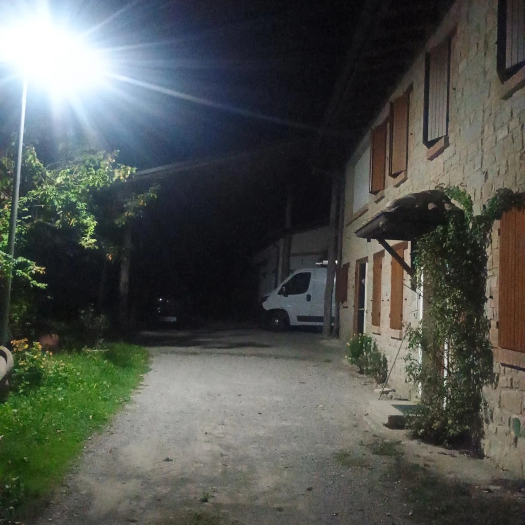 Foto de un cliente: una callejuela de pueblo entre las casas, de noche, iluminada como de día por el foco